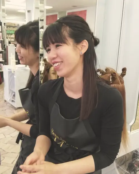 Valentina sorride durante il lavoro in salone